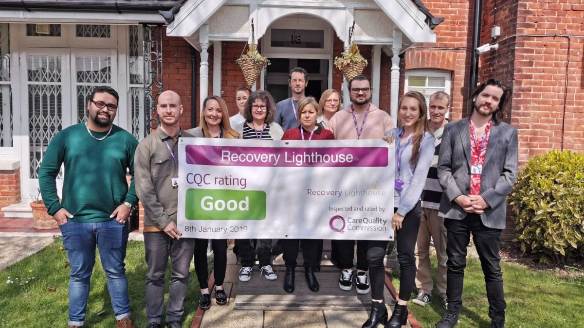 recovery lighthouse team holding cqc result banner